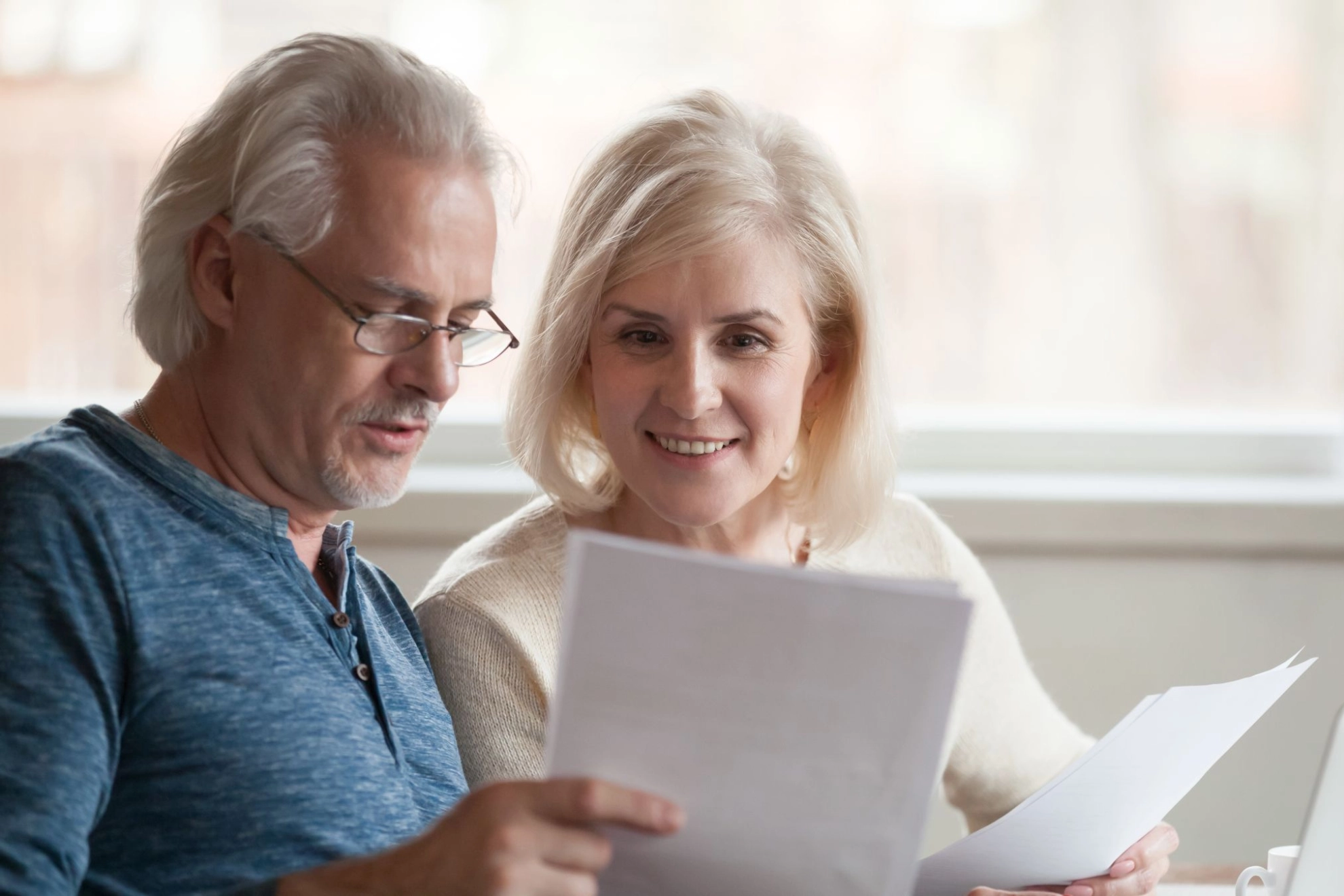 zwei ältere Menschen betrachten gemeinsam Unterlagen